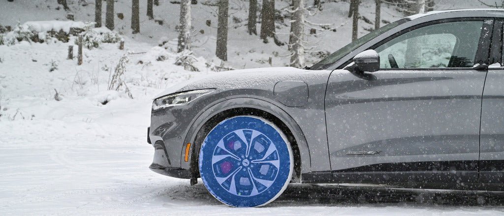 Side view of a Ford Mustang with mounted SnowGecko tire chains on driving wheels