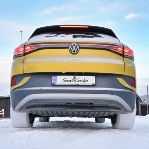 Lower rear view of Volkswagen passenger car with SnowGecko tire chains mounted on rear wheels